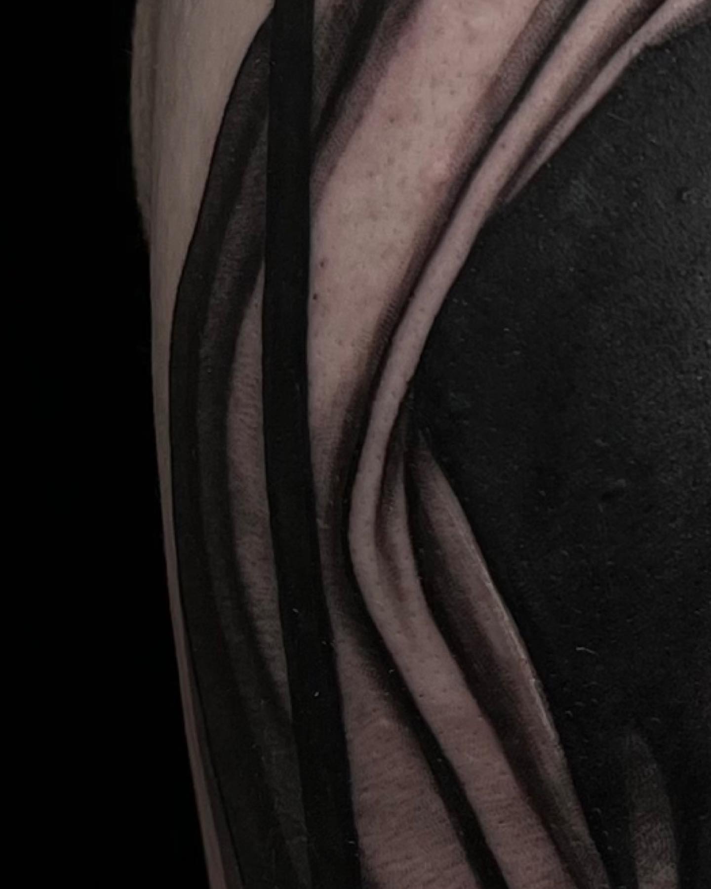 Abstract pattern black and grey tattoo on the upper arm by Madison Ast Tattoo
