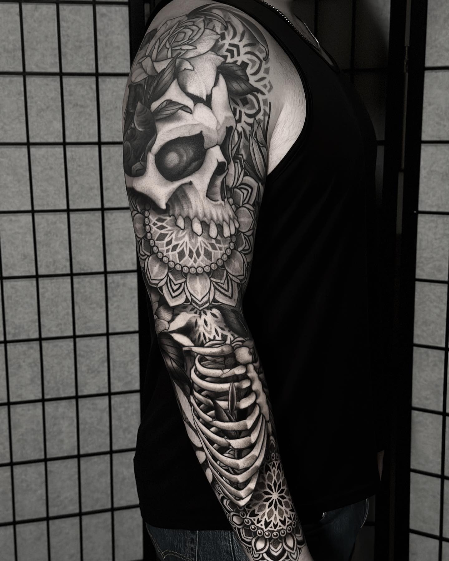 Skull realism tattoo on the upper arm by San Diego