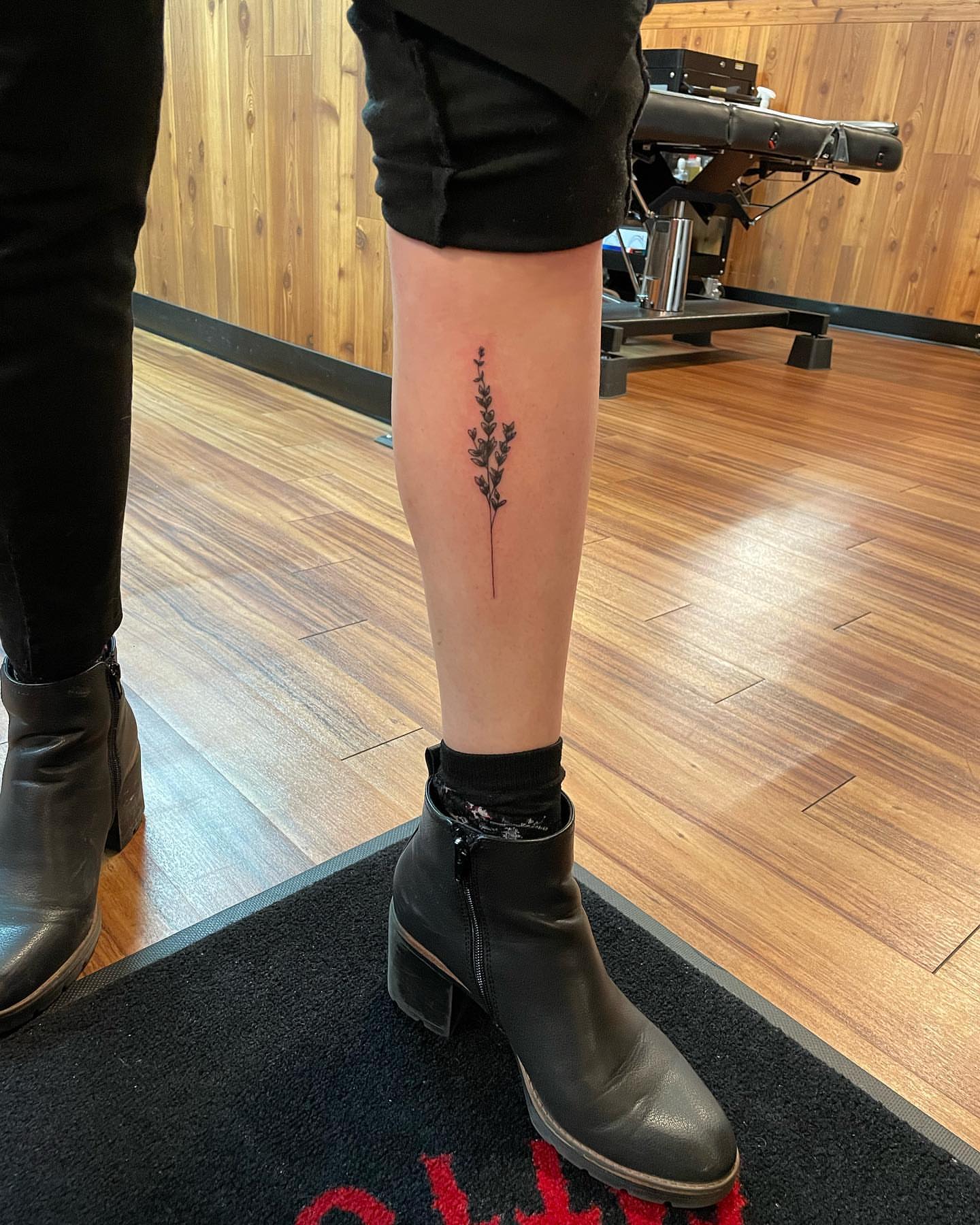 Plant black and grey tattoo on the calf by Anna sabrowsky