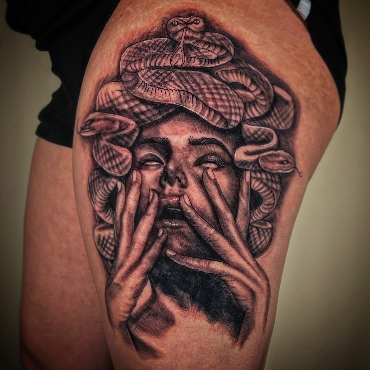 Snake and hands realism tattoo on the thigh by David Mariscal