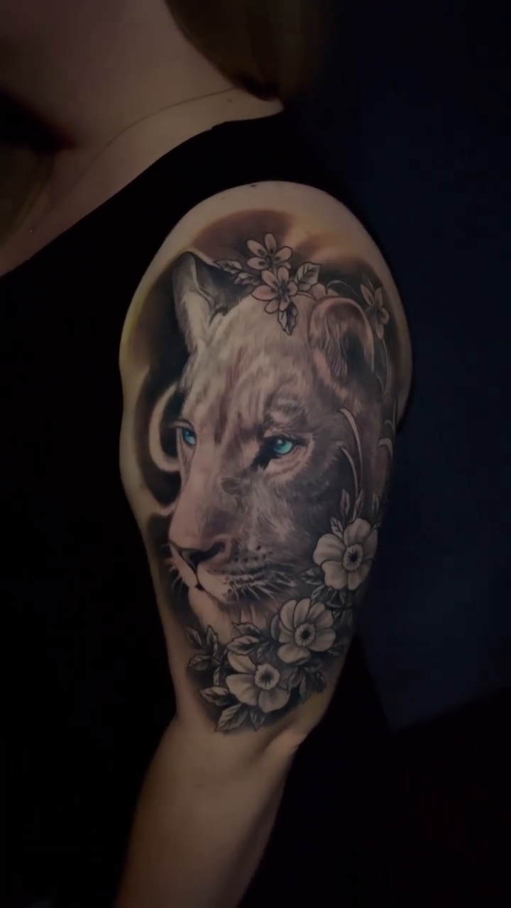 Lioness portrait with flowers realism tattoo by Joe Shepp