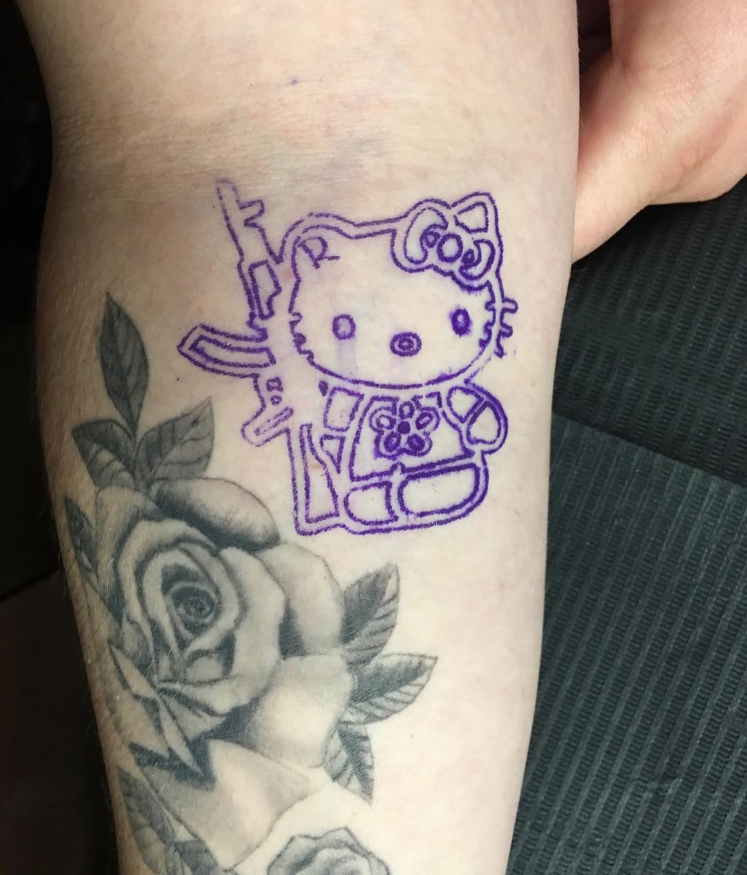 Hello Kitty with a rifle new school tattoo on the forearm by Ramirez Tattooing