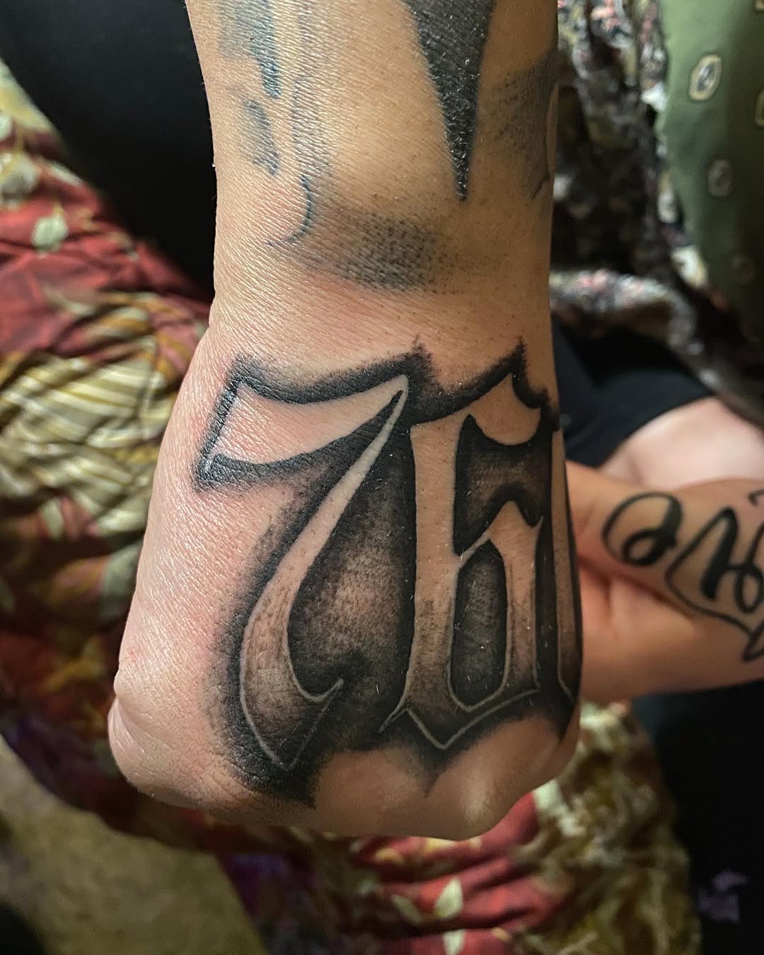 76 script lettering Chicano tattoo on the foot by Ramirez Tattooing