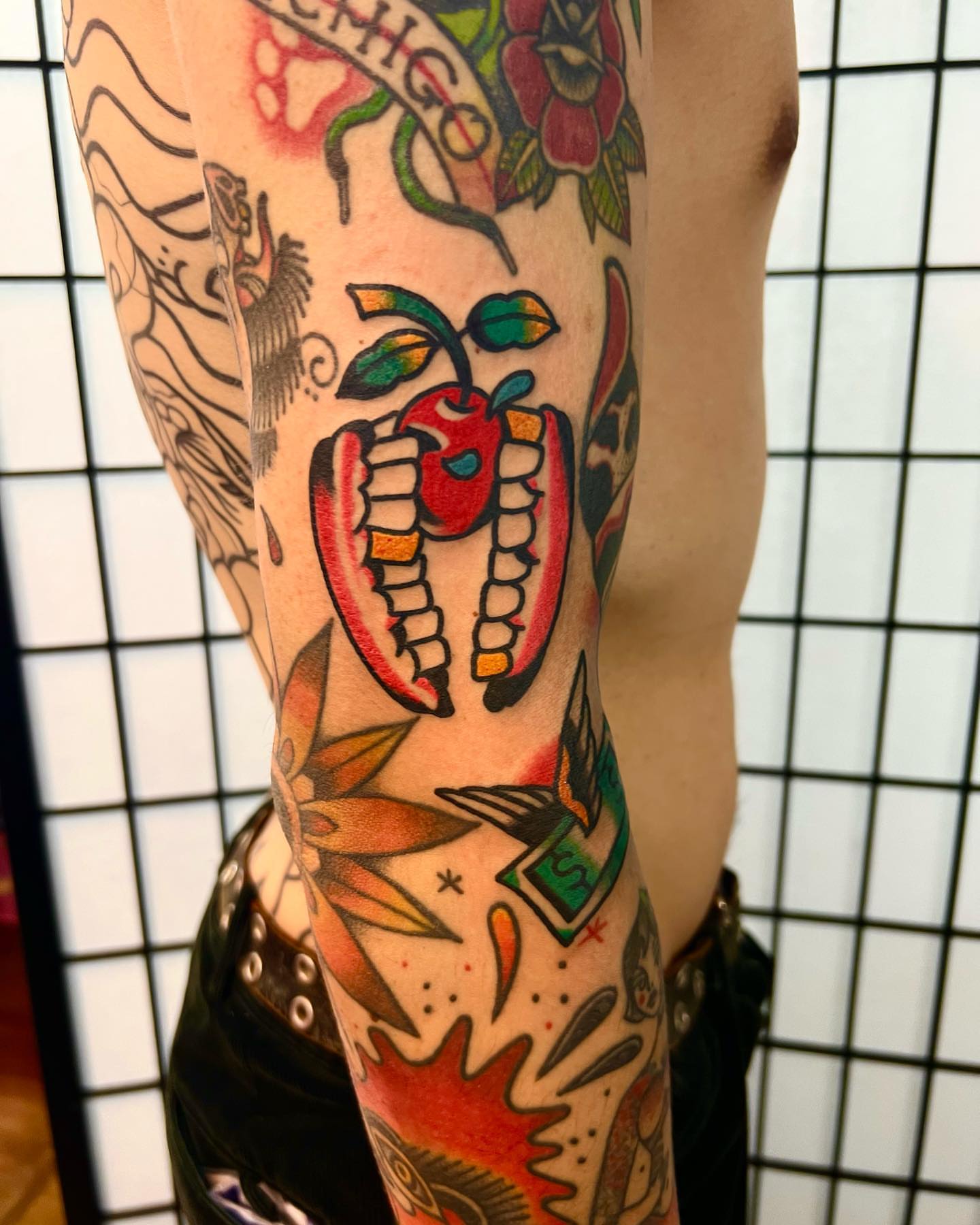 Apple and teeth American traditional tattoo on the forearm by Nicholas Mella, Nashville, Tennessee