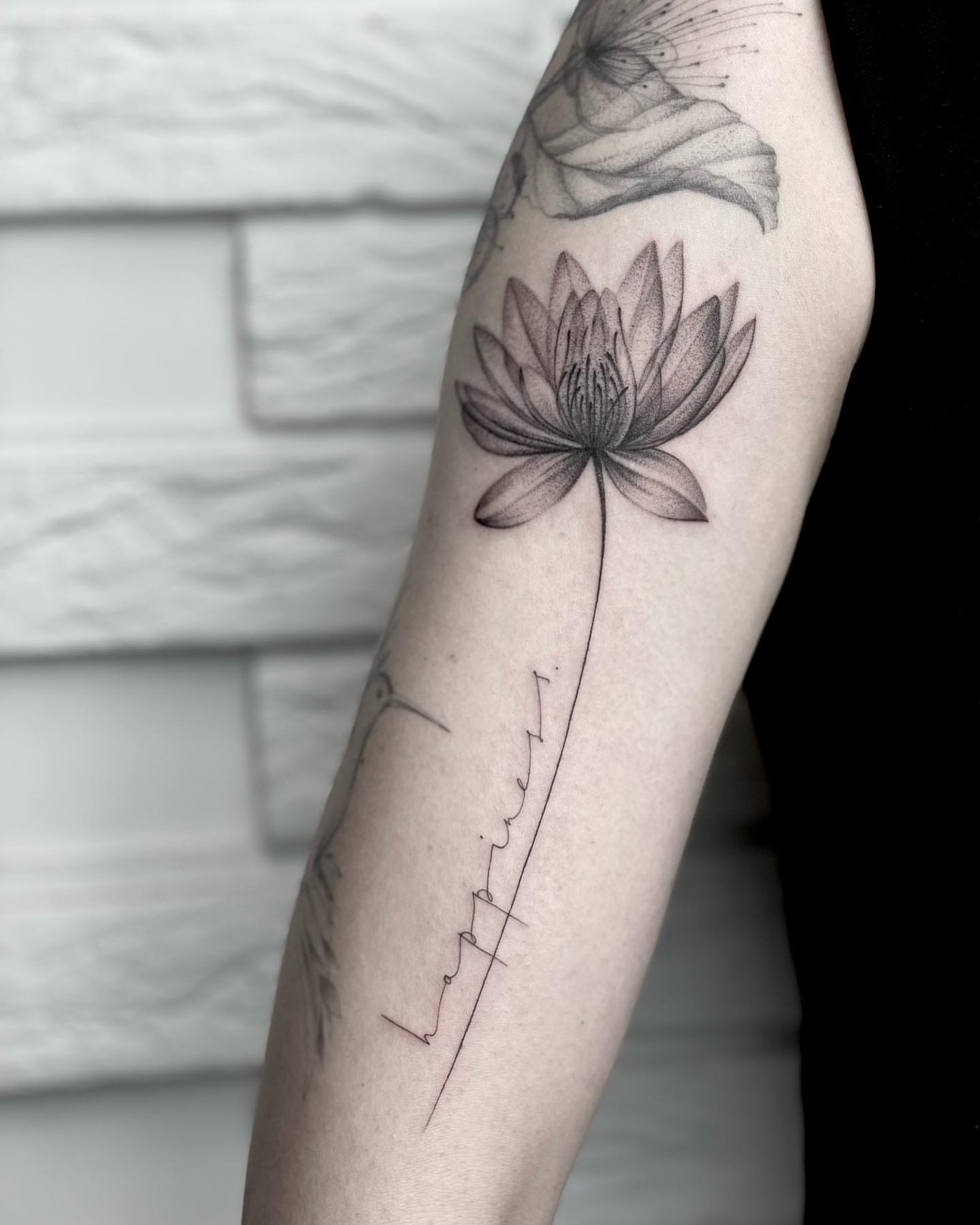 Lotus flower black and grey tattoo on the forearm by Annie Overchuk