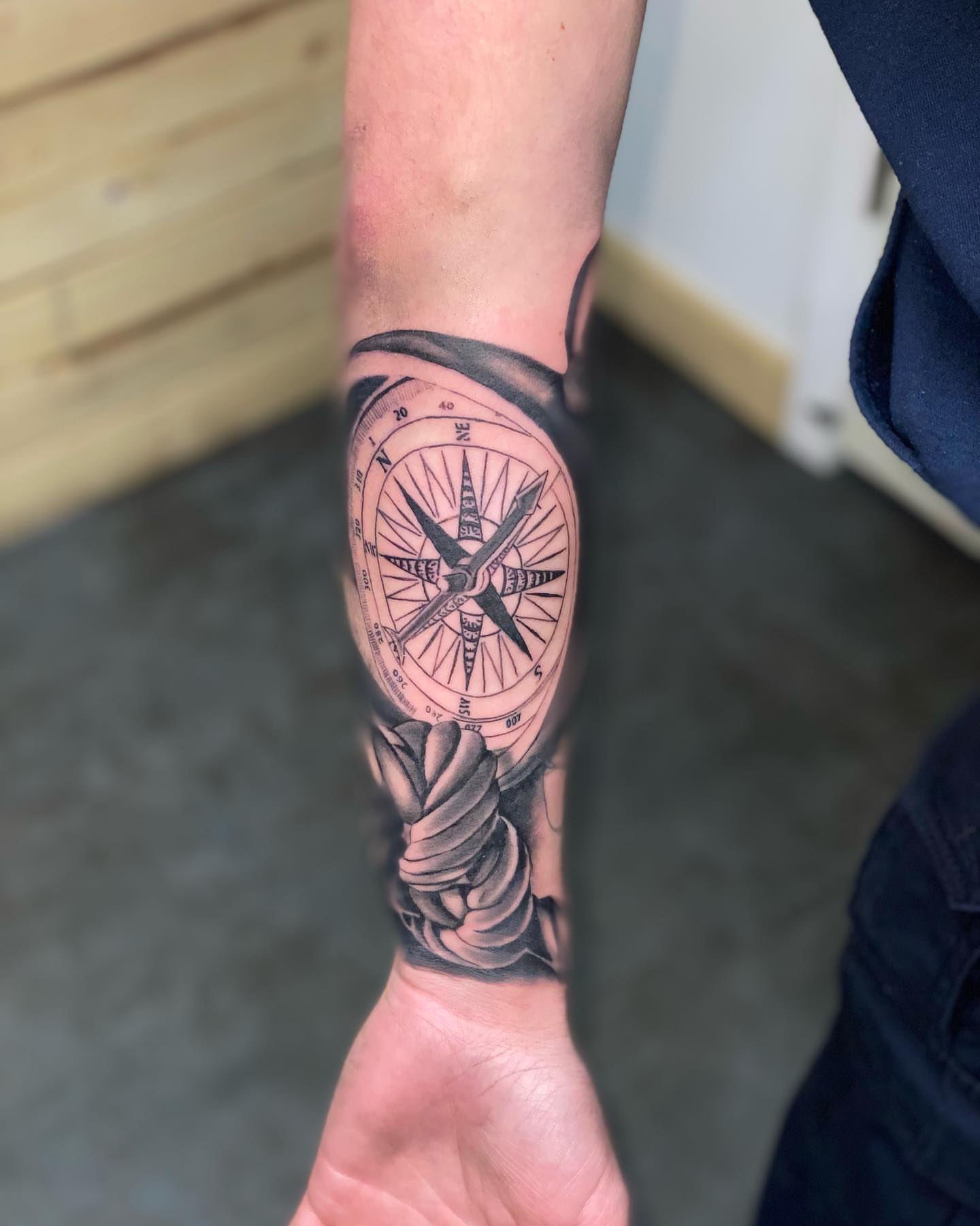 Compass black and grey tattoo on the forearm by Zach Ashton