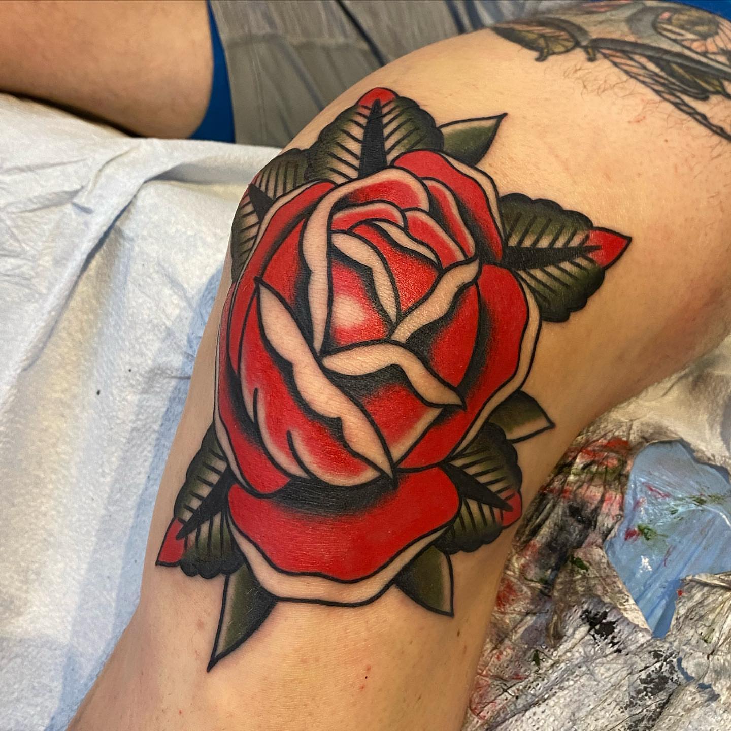 Red rose American traditional tattoo on the thigh by andrewtattoos