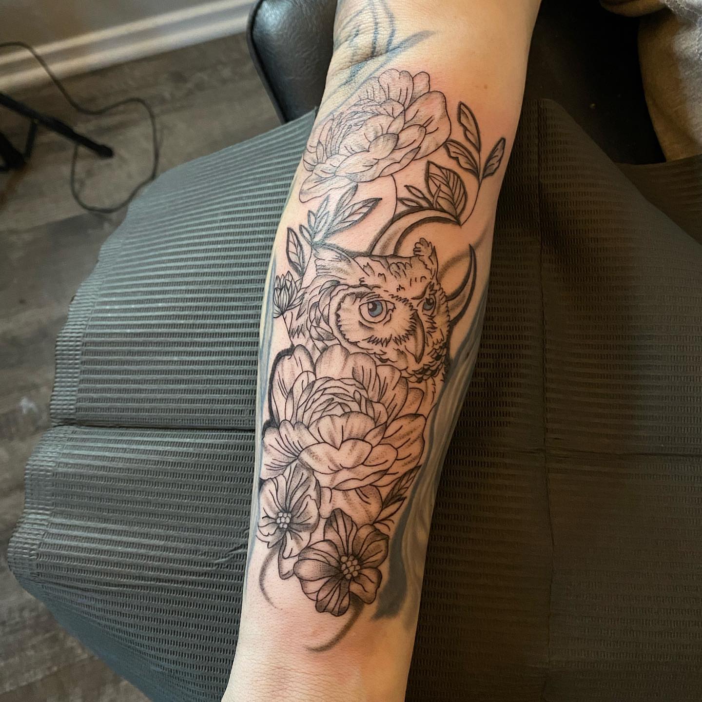 Owl and flowers realism tattoo on the forearm by @tattoosbyskyeee