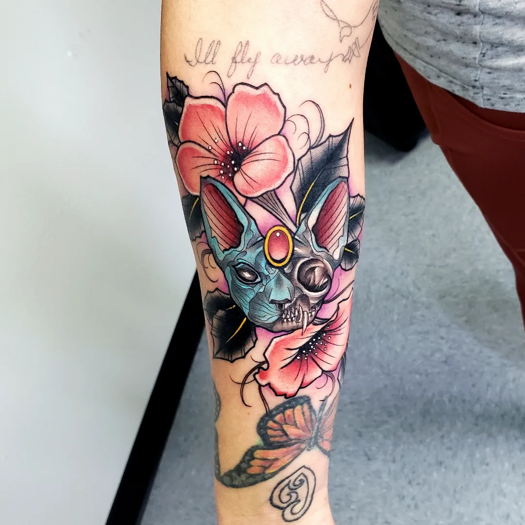 Skull with flowers American traditional tattoo on the forearm by Jake Lee