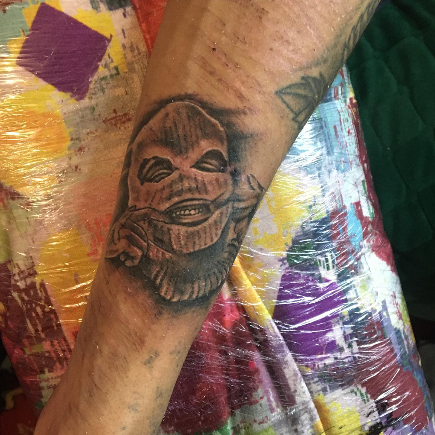 Mask black and grey tattoo on the forearm by la flamme