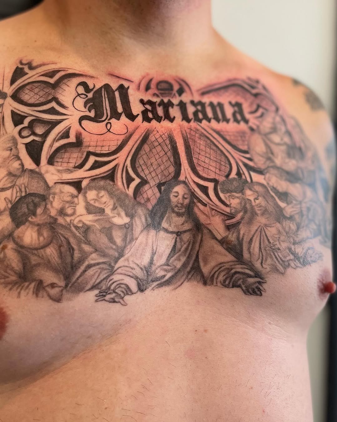 Religious scene with name tattoo on the chest by Antonio