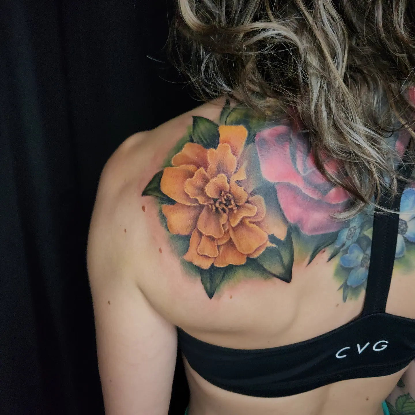 Orange flower realism tattoo on the shoulder by Don Taylor