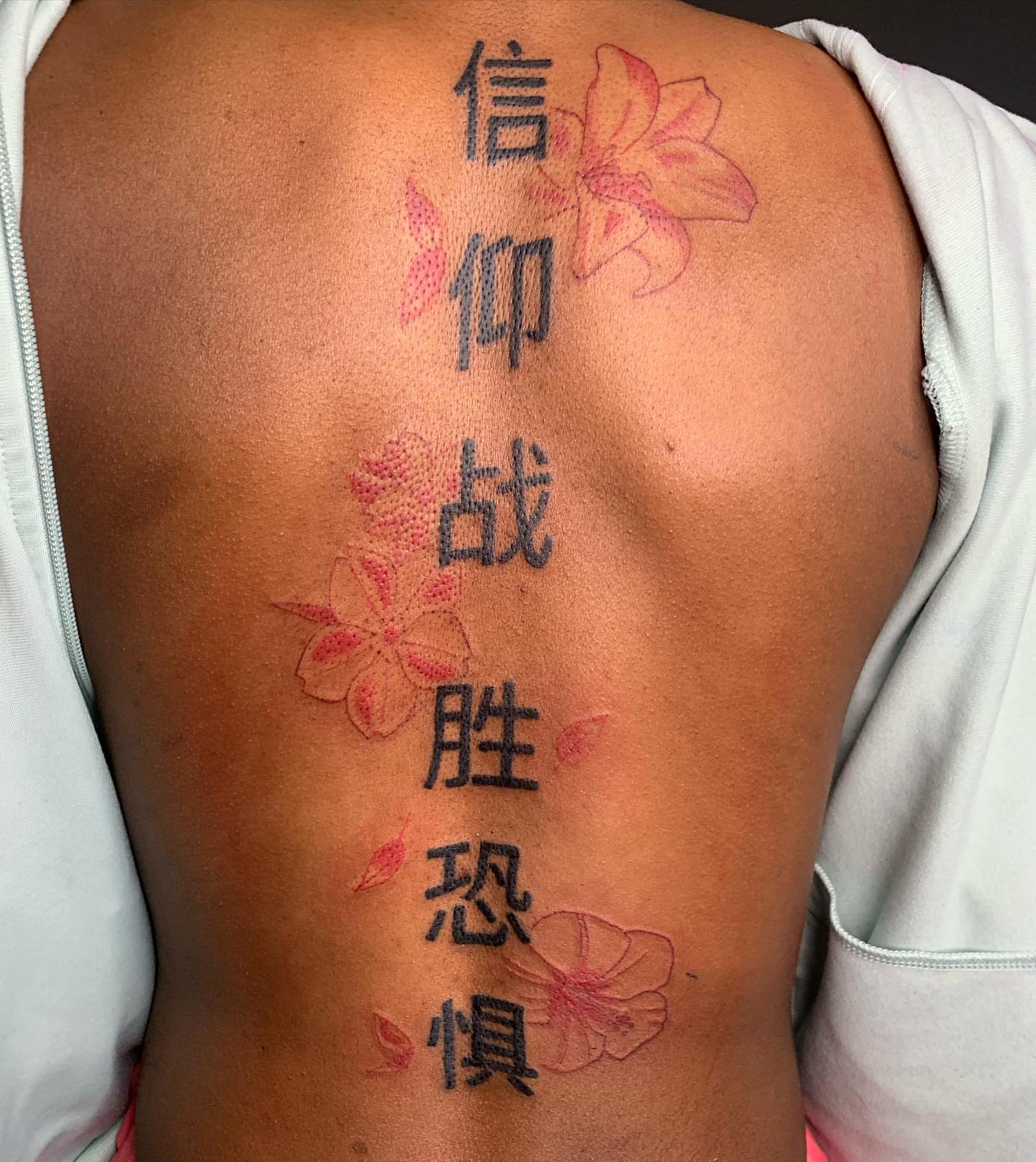Chinese characters and flowers dotwork tattoo on the back by Evan Chastain
