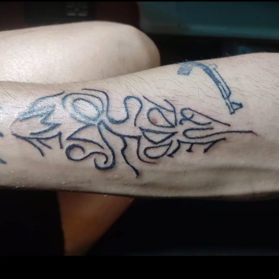 Abstract tribal script blackwork tattoo on the forearm by Tatuadora & Piercer