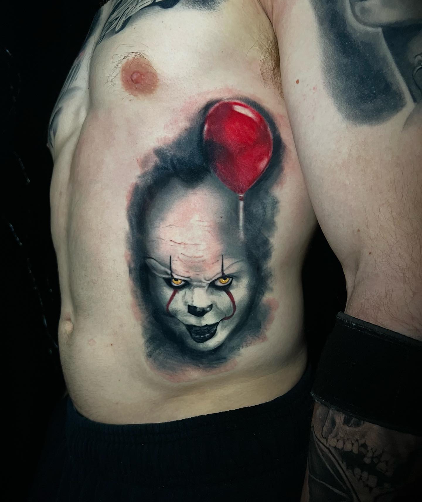Pennywise realism tattoo on the chest by Travis Thorpe