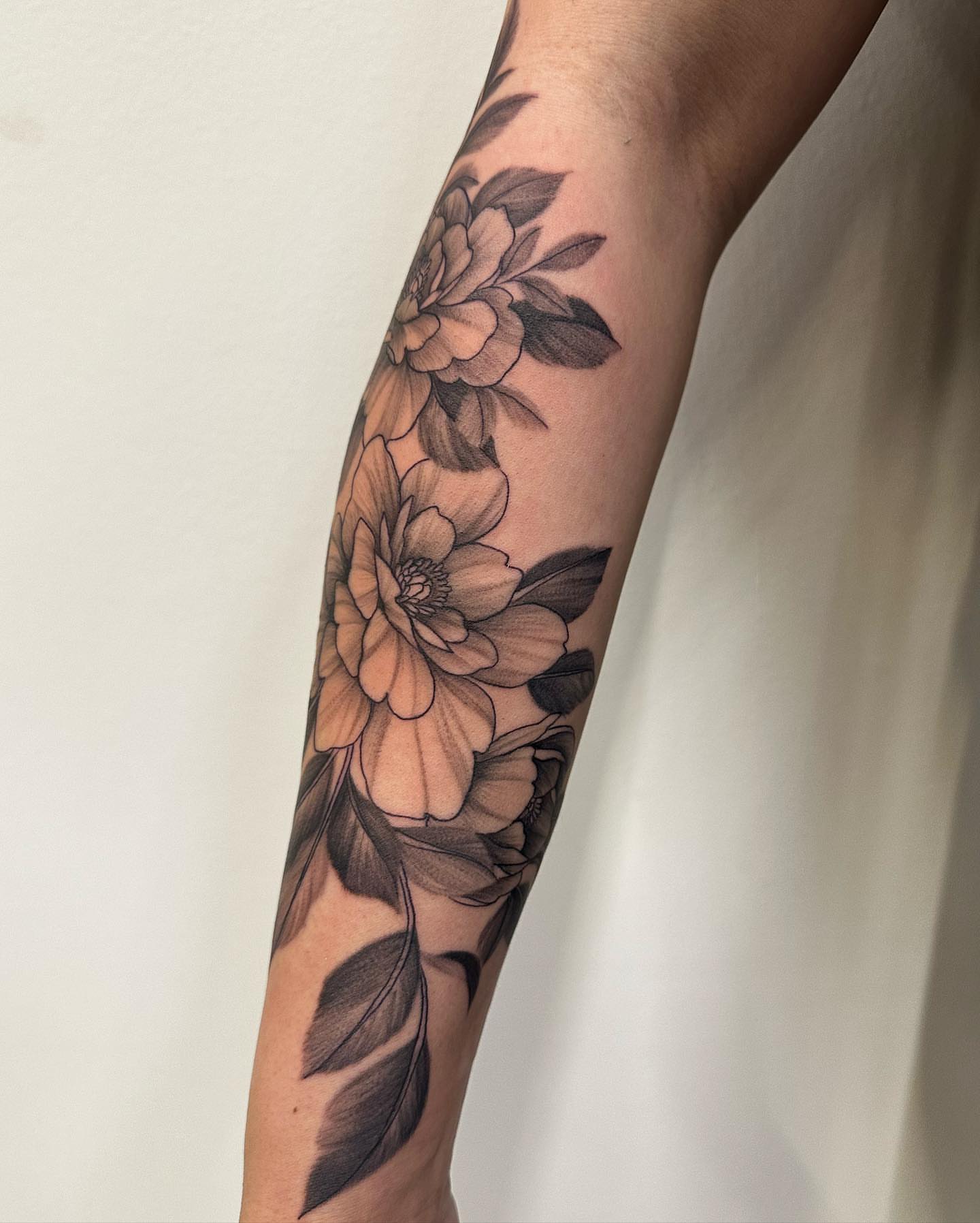 Flowers black and grey tattoo on the forearm by Sam Oakes