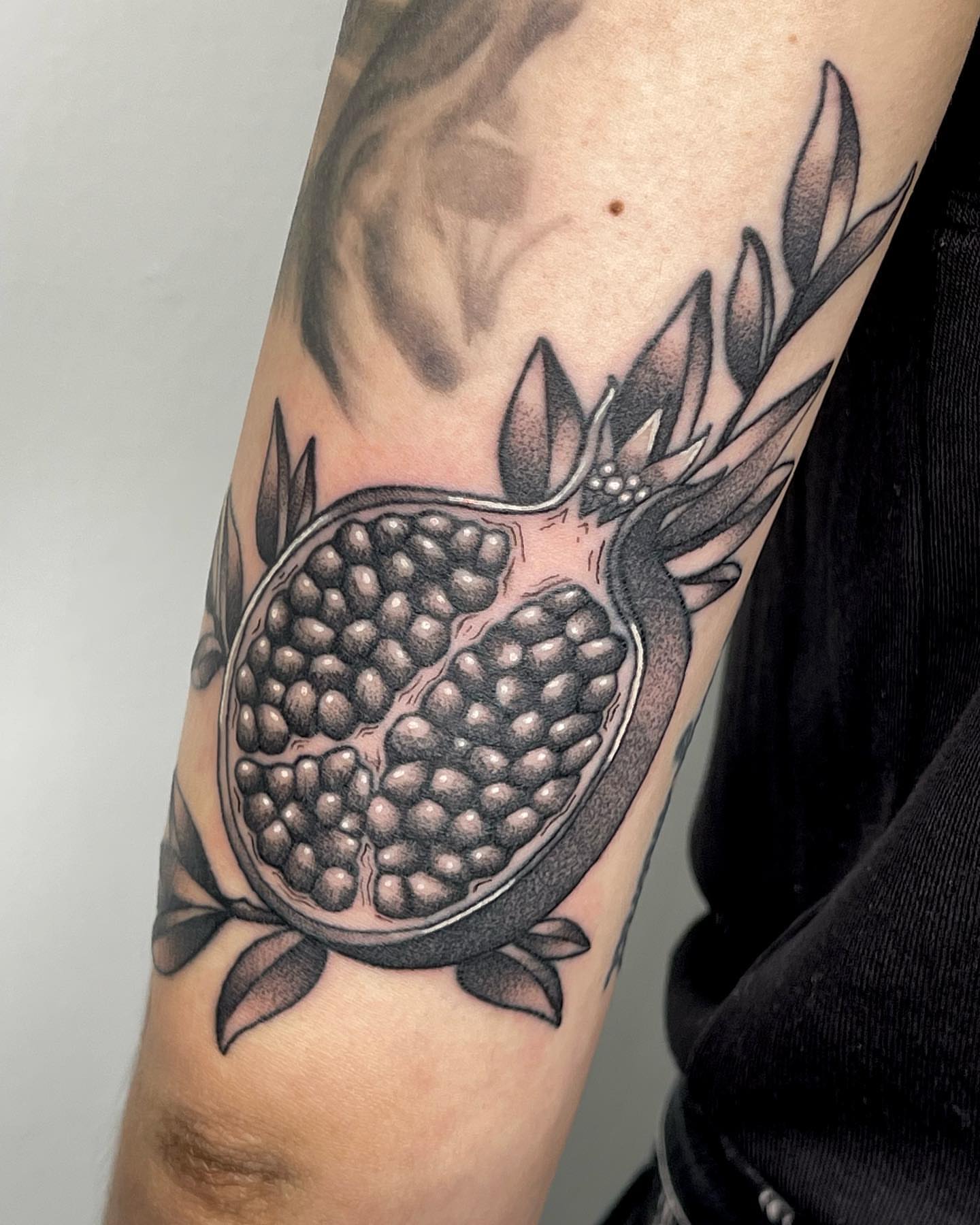 Pomegranate dotwork tattoo on the forearm by Anastasia Vives