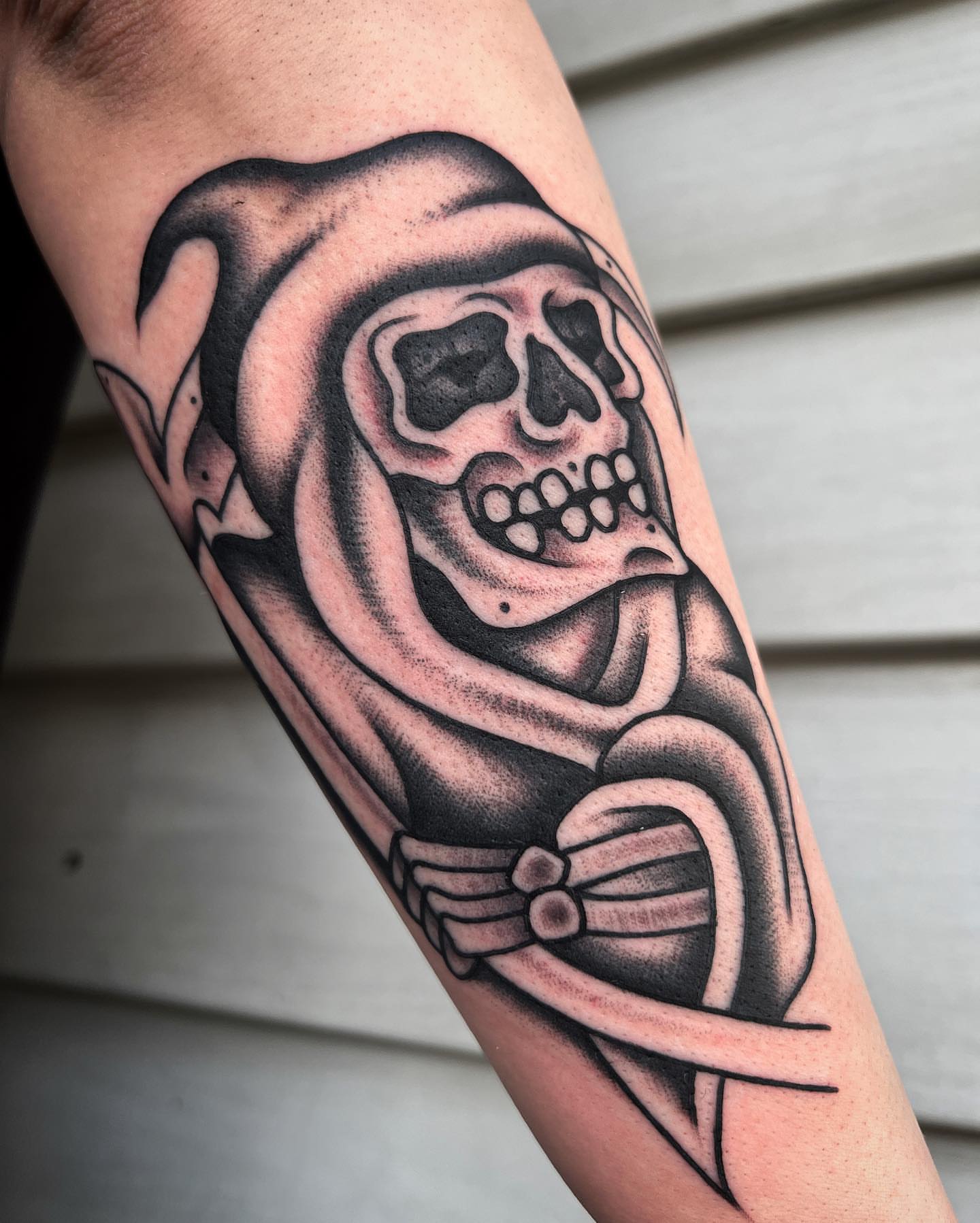 Skull black and grey tattoo on the forearm by Daniel Mesen
