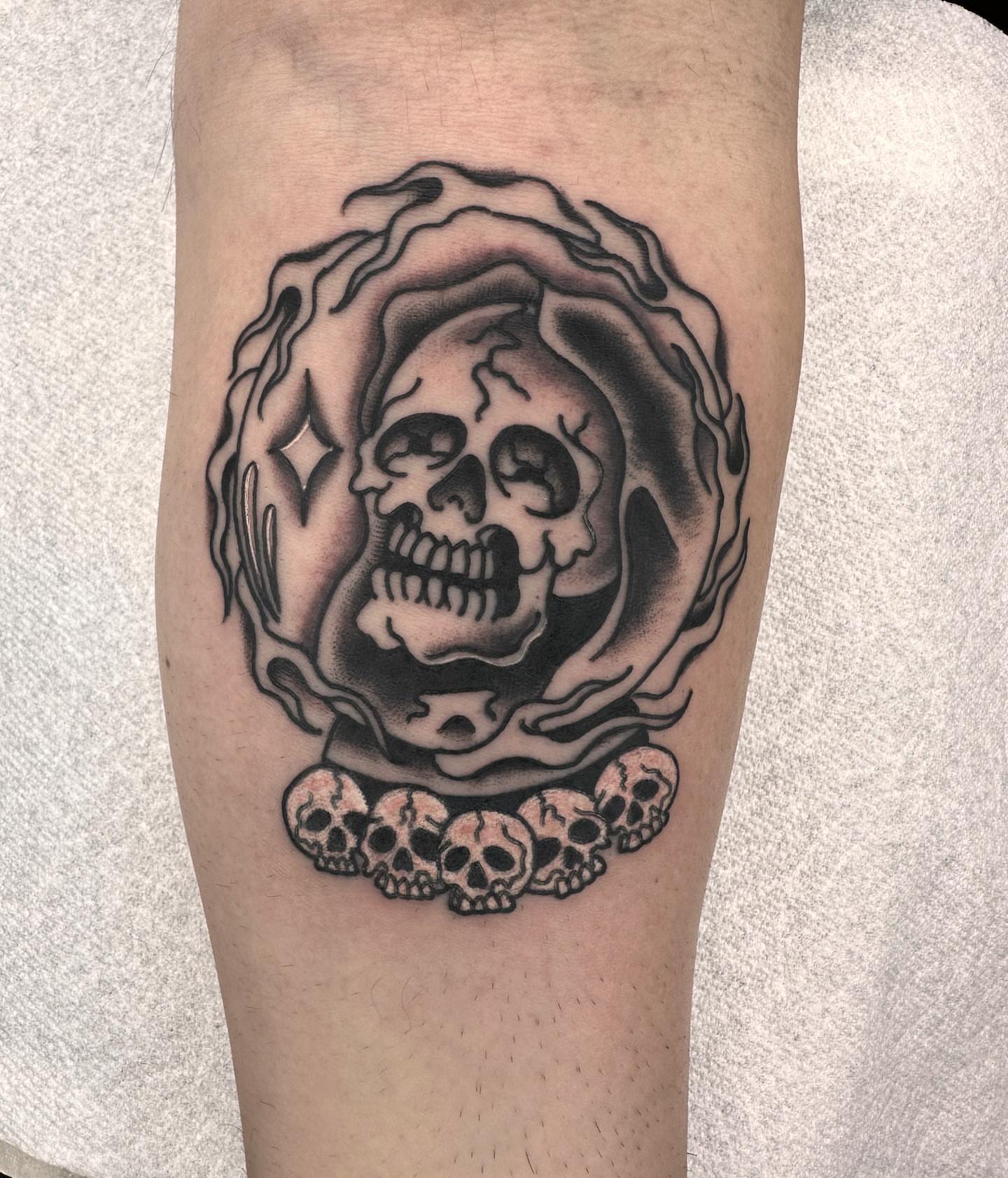Skull and flames black and grey tattoo on the forearm by Elijah Edwards