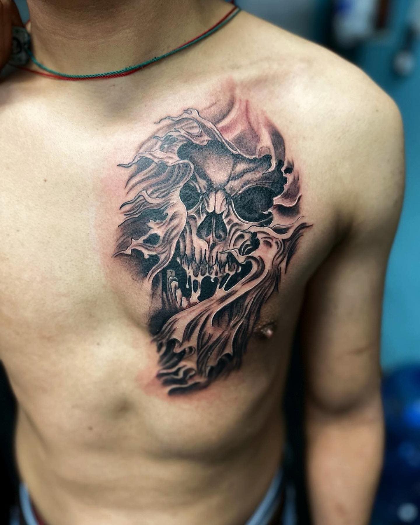 Flaming skull dark realism tattoo on the chest by Alberto Ramirez
