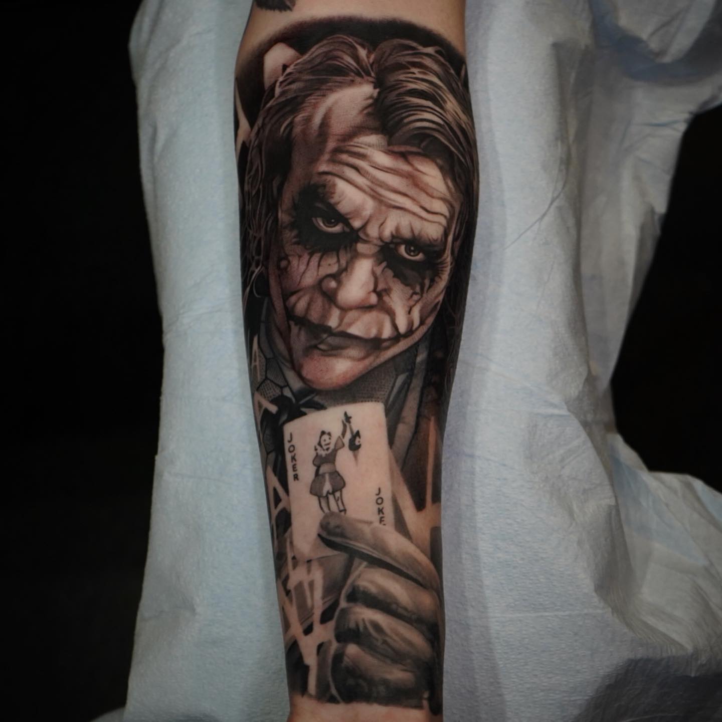 Joker realism tattoo on the forearm by Bradley Dozier