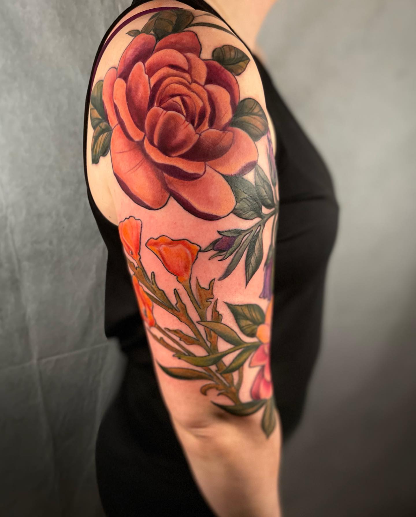 Rose realism tattoo on the upper arm by 𝓚𝓪𝓼𝓼𝓪𝓷𝓭𝓻𝓪 𝓜𝓬𝓒𝓪𝓵𝓵, Eugene, Oregon