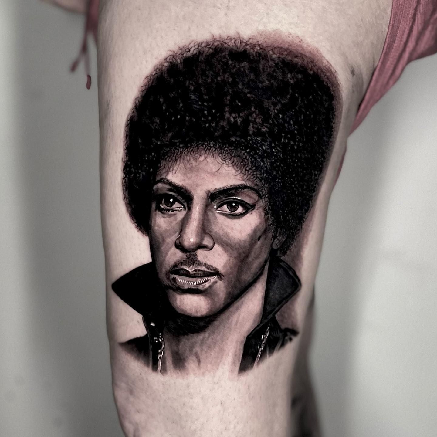 Prince portrait realism tattoo on the forearm by Jeremiah Warner