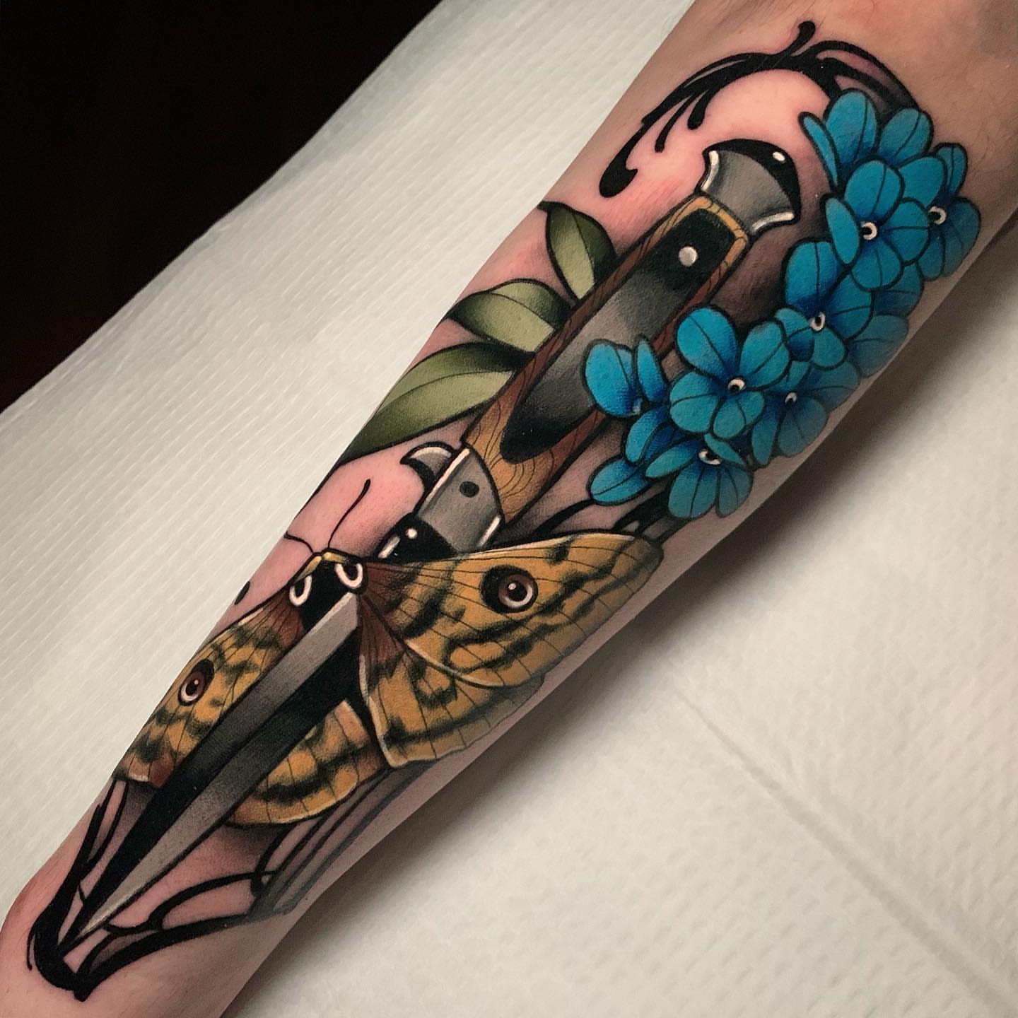 Knife and moth American traditional tattoo on the forearm by gillian marie
