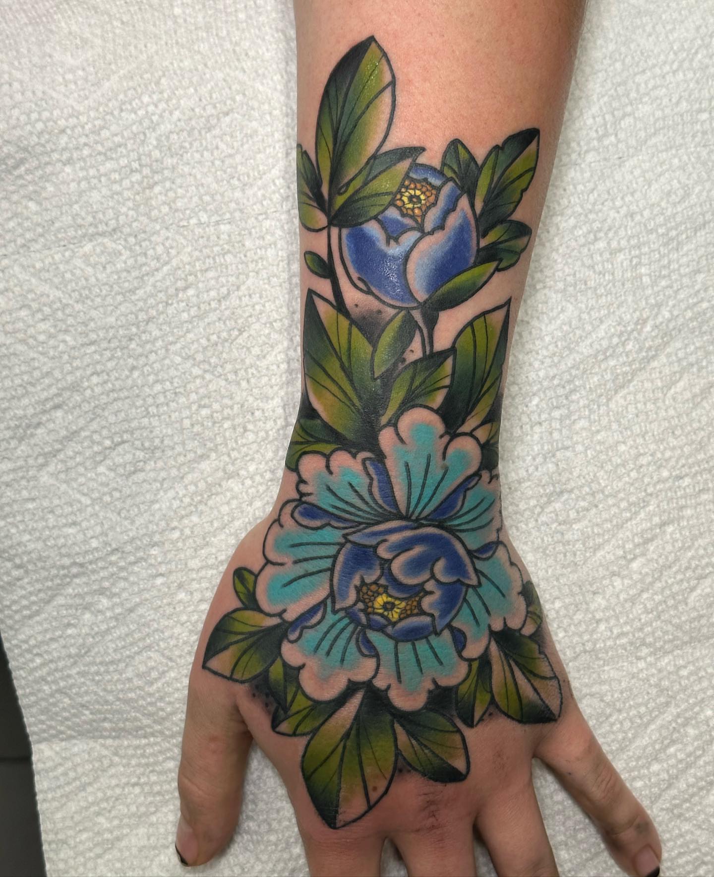 Floral arrangement American traditional tattoo on the hand by 𝕯𝖗𝖊𝖜 𝕲𝖎𝖑𝖊𝖘 𝕵𝖆𝖙𝖙𝖔𝖔, Addison, Texas