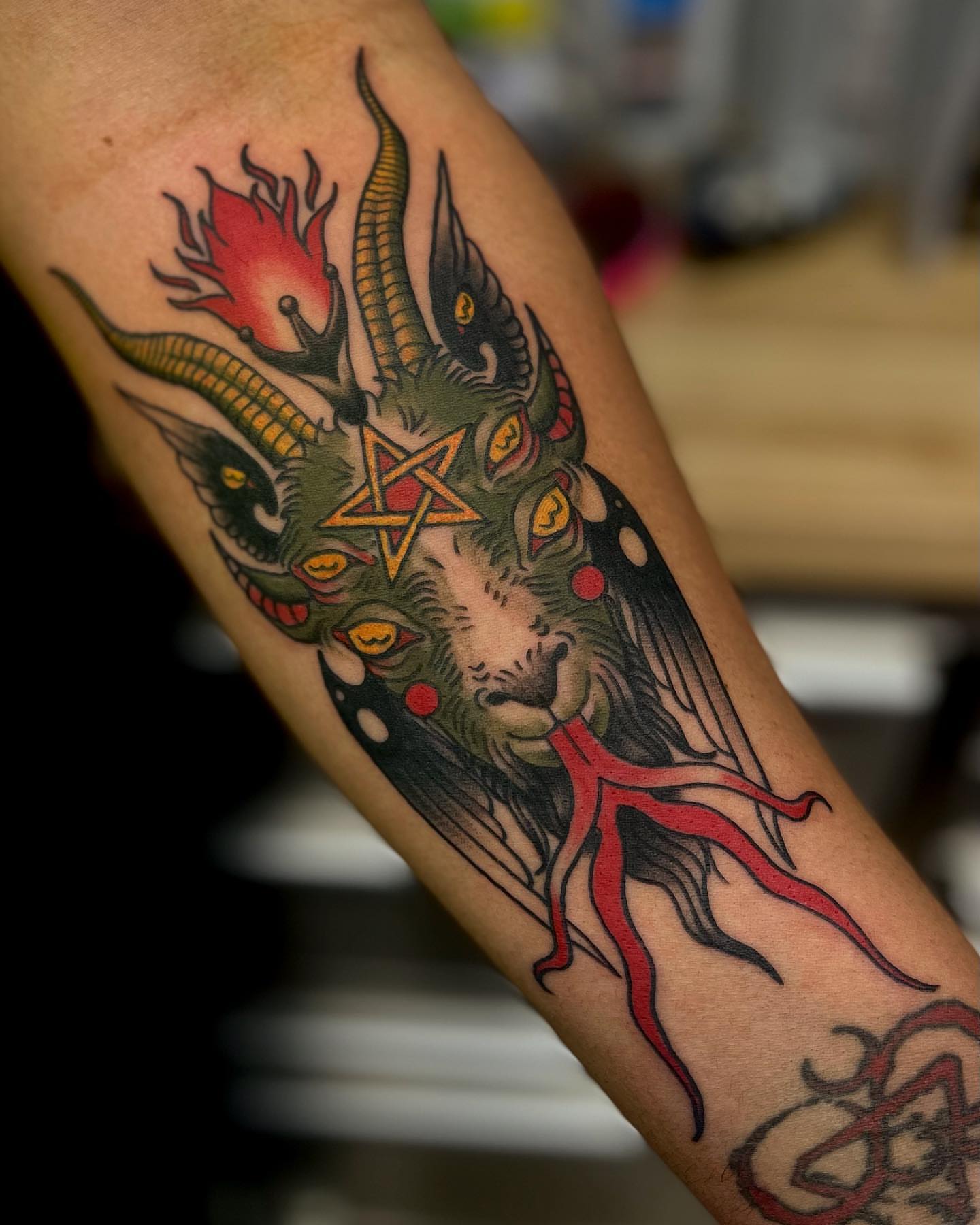 Goat head with pentagram American traditional tattoo on the forearm by Morgan Jones