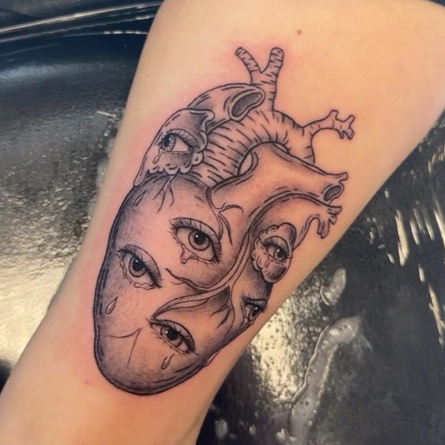 Heart with faces realism tattoo on the forearm by Summers