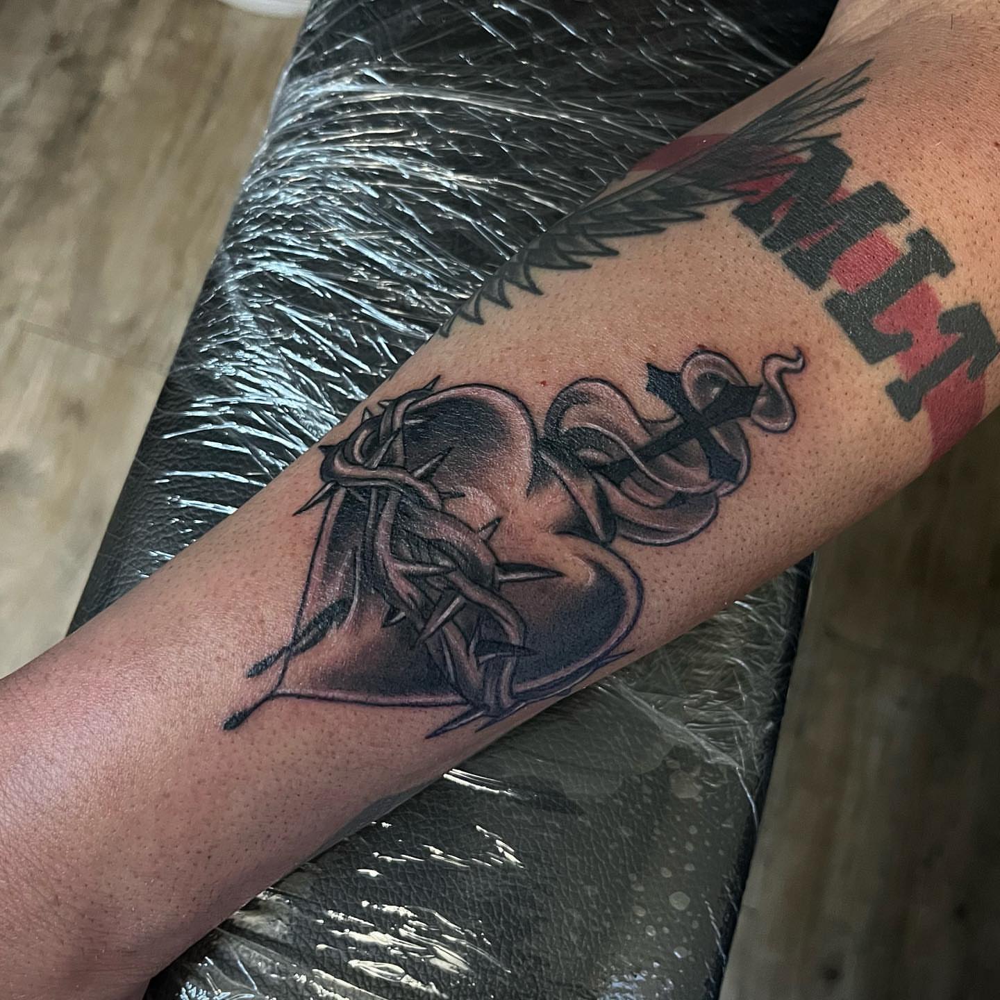 Heart with thorns black and grey tattoo on the forearm by Christopher McGlone