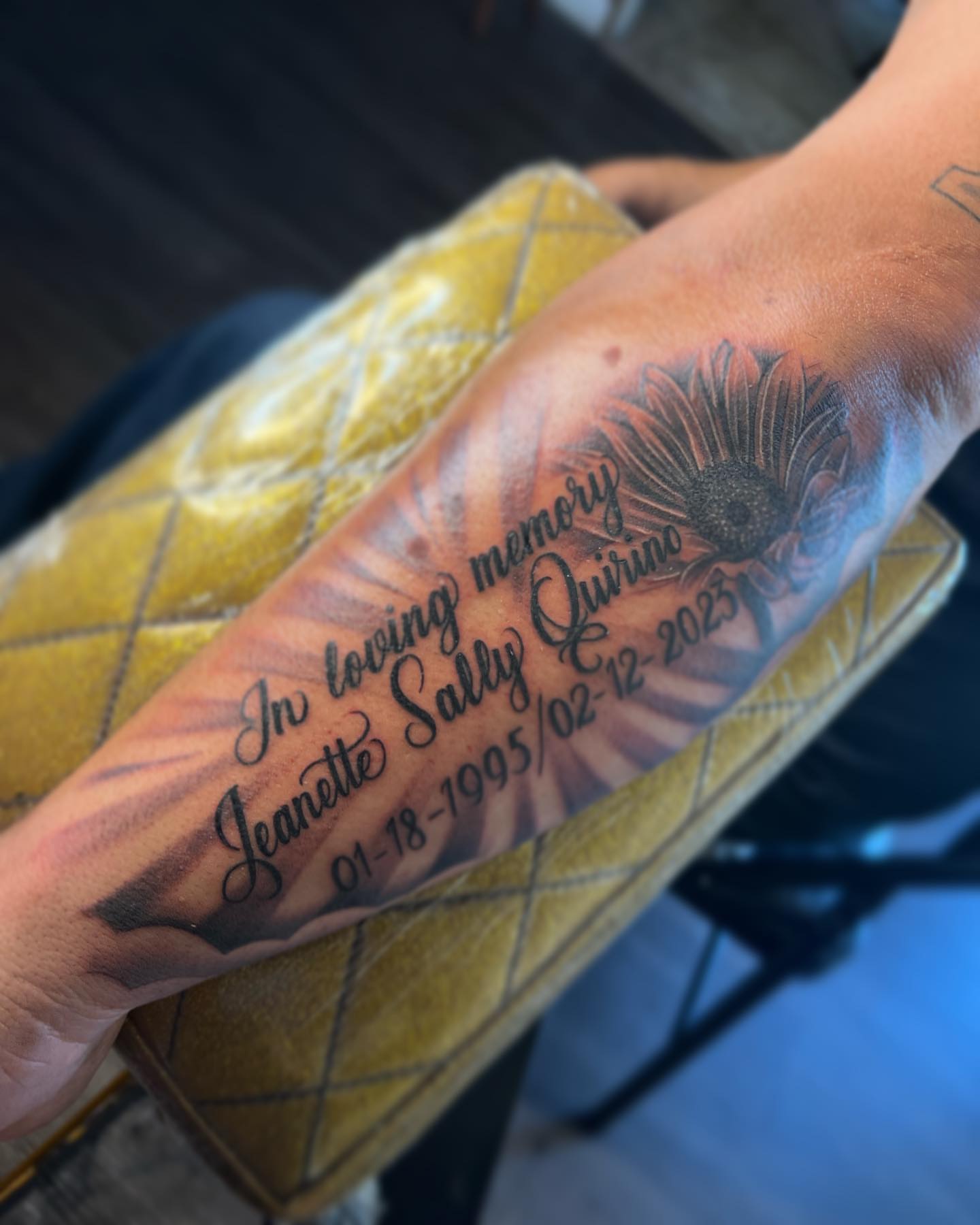 Sunflower and inscription black and grey tattoo on the forearm by Bree Quirino