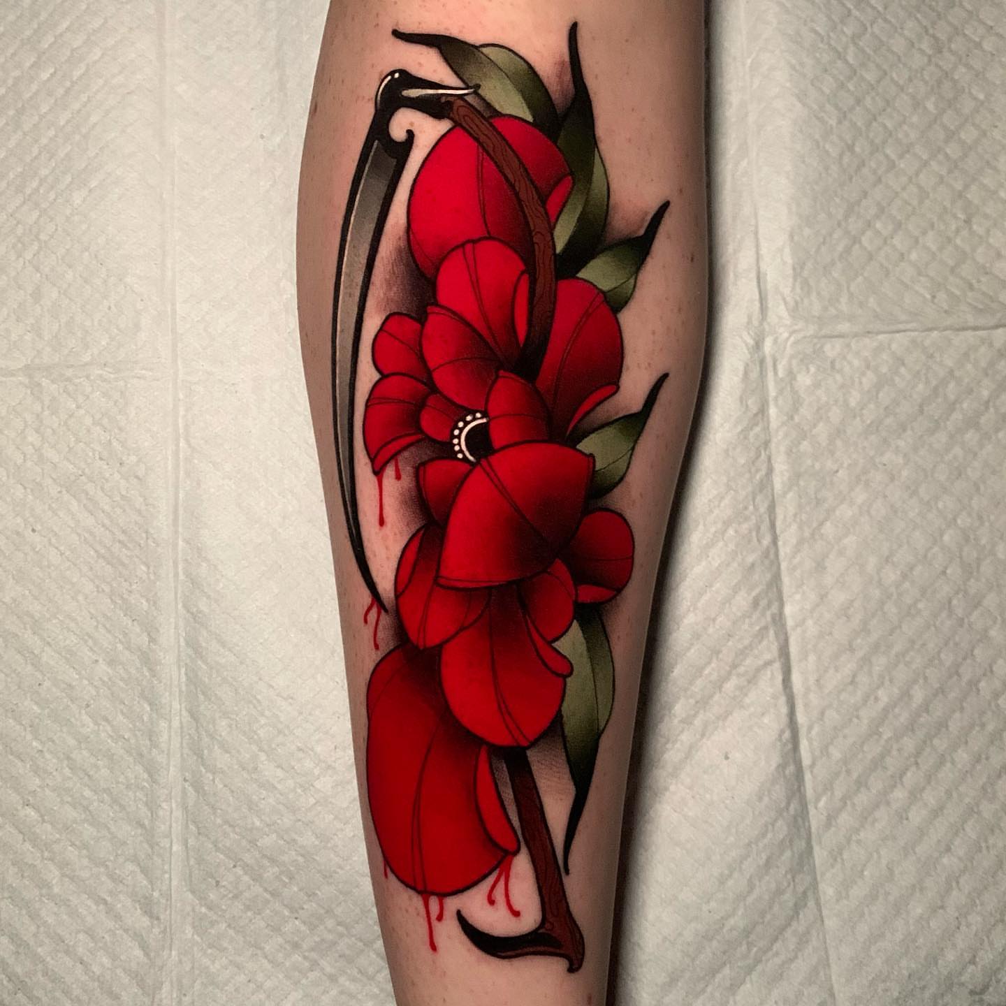 Red flowers realism tattoo on the forearm by gillian marie