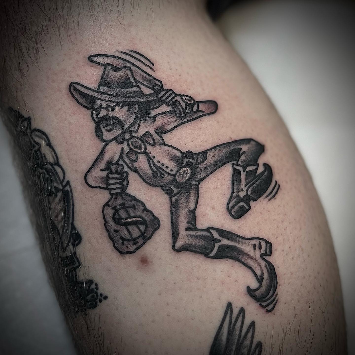 Cowboy kicking black and grey tattoo on the thigh by Troy Mort, Altoona, Pennsylvania