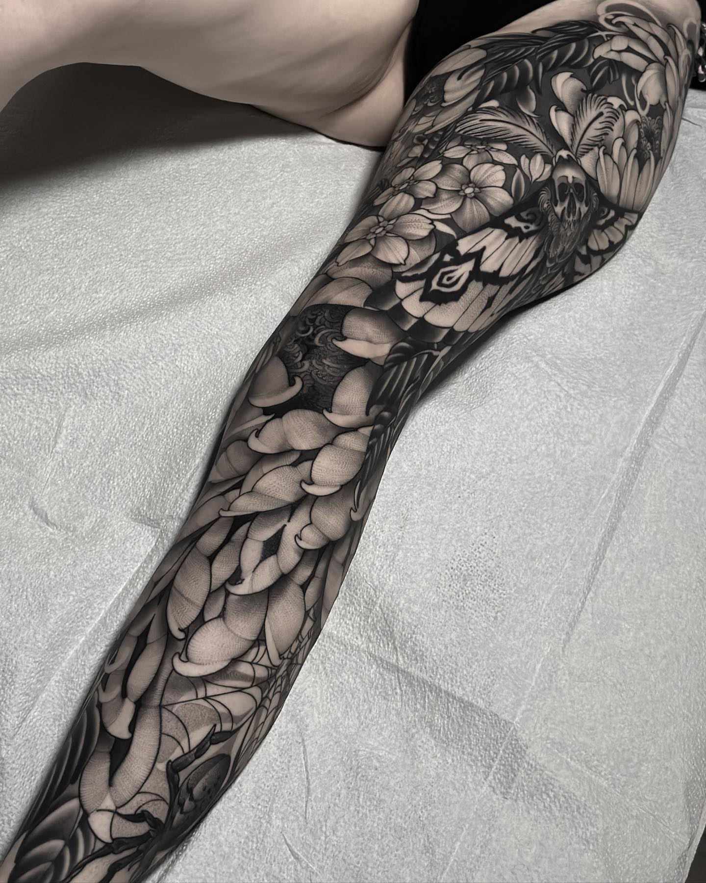 Floral and butterfly black and grey tattoo on the forearm by San Diego
