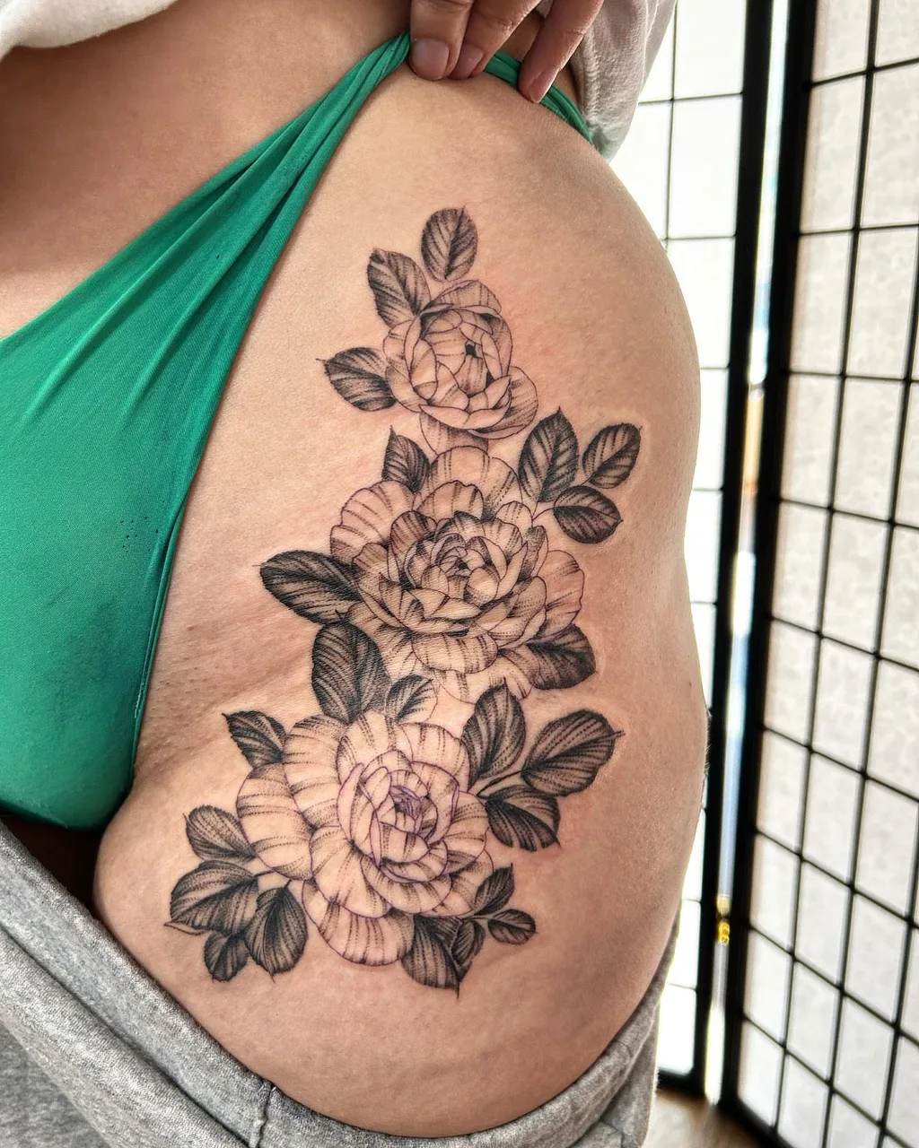 Roses black and grey tattoo on the thigh by Dylan Stevens