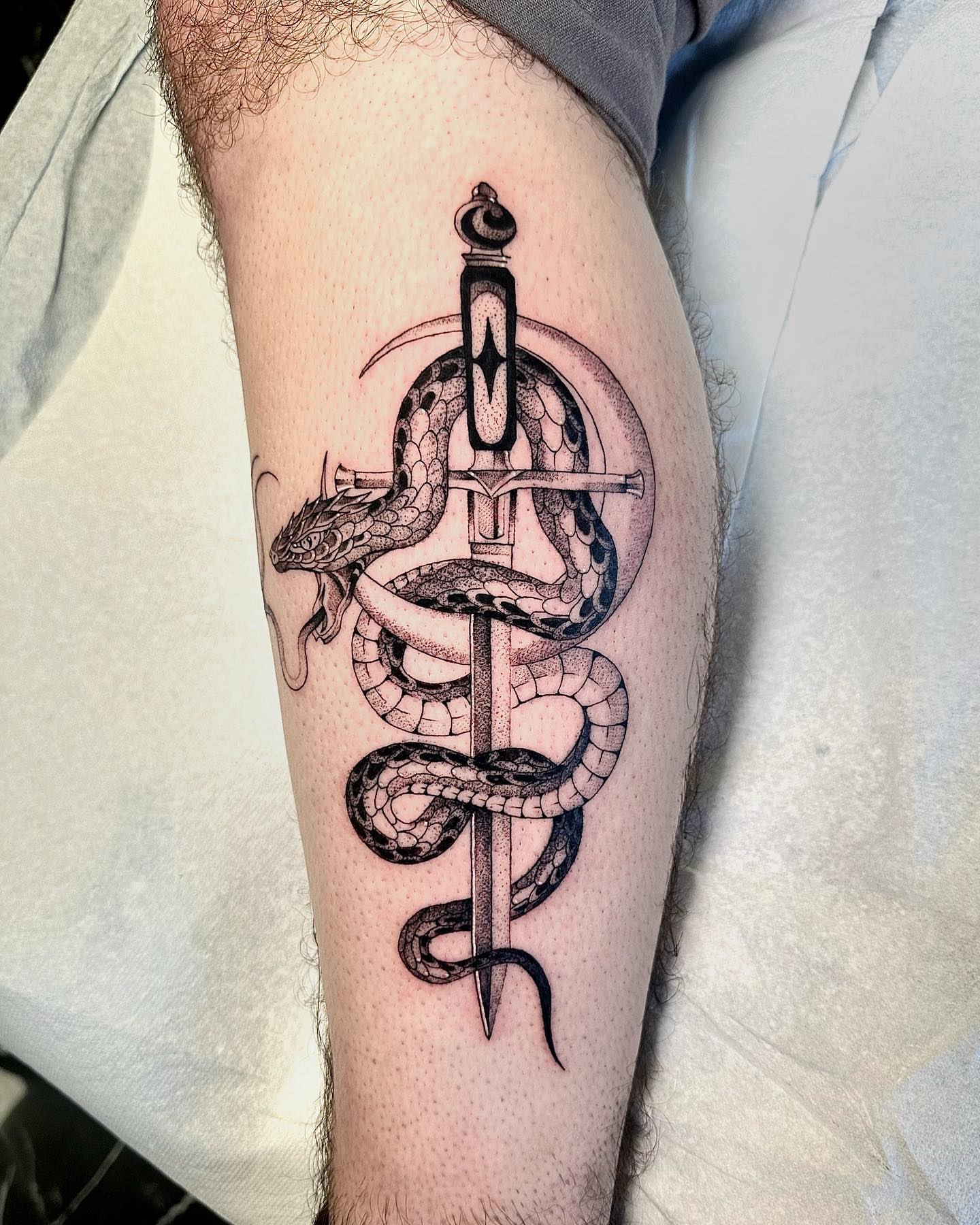 Snake and sword geometric tattoo on the forearm by Fine line tattoo San Diego, San Diego, California