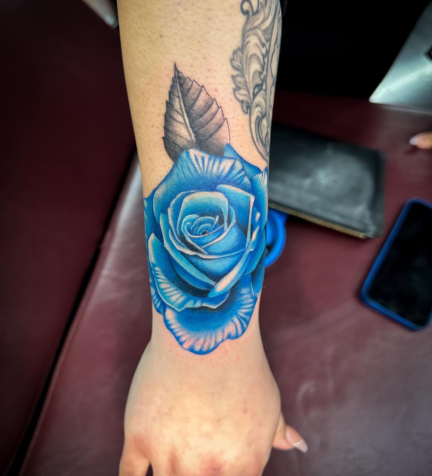 Blue rose realism tattoo on the forearm by Tattoos by Rey G.
