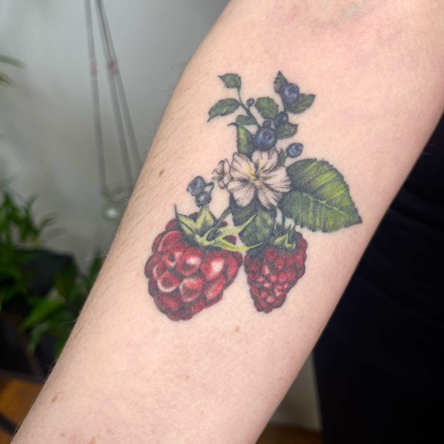 Raspberries and flowers realism tattoo on the forearm by 𓆏 Alyssa Carbonara 𓆏