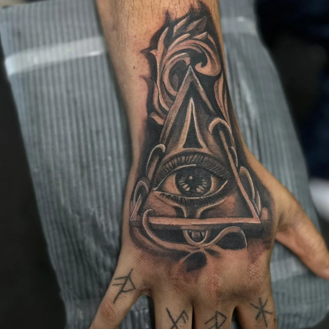 Eye and pyramid geometric tattoo on the hand by Daniel Illachek
