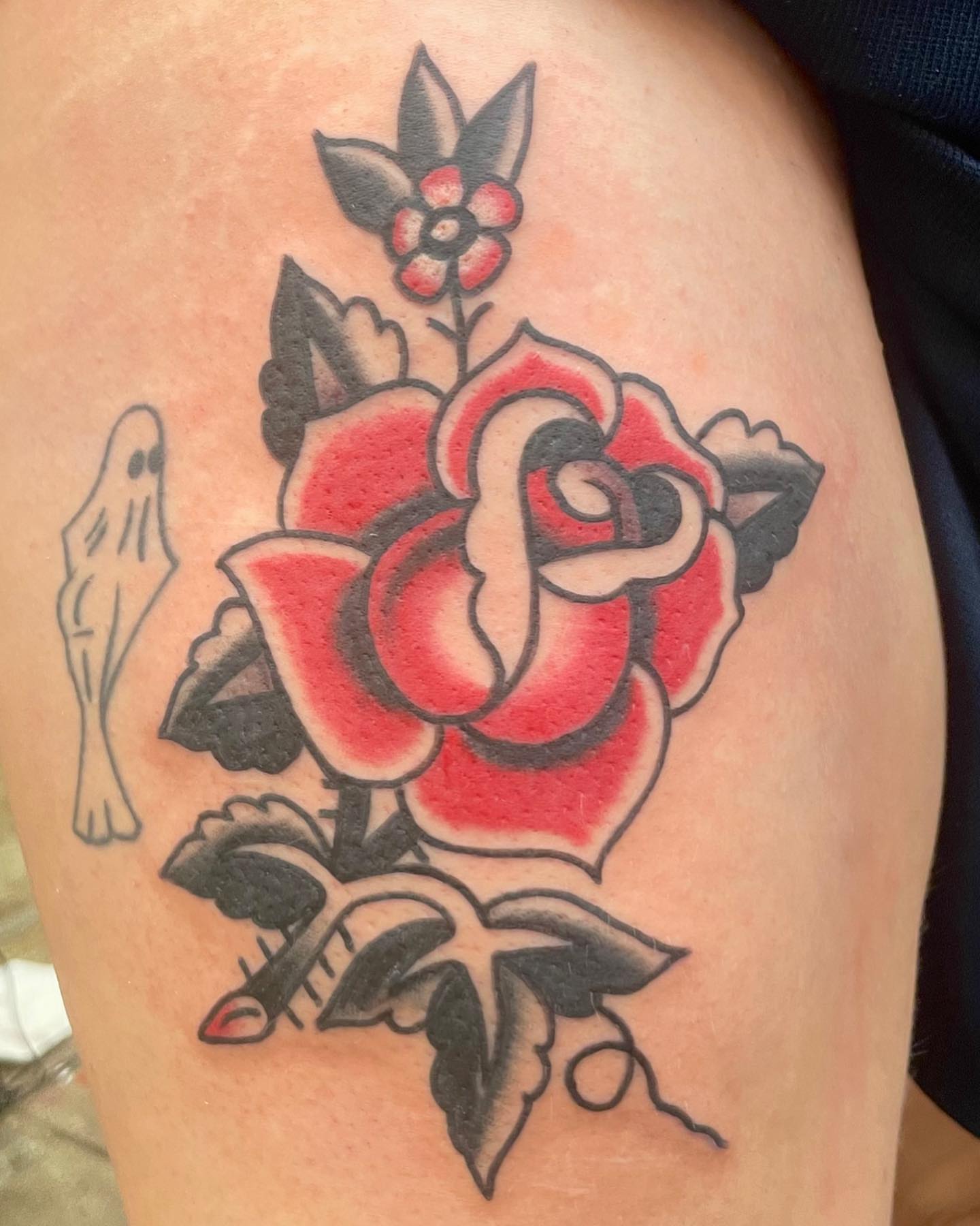 Red rose American traditional tattoo on the thigh by Seth Griffin
