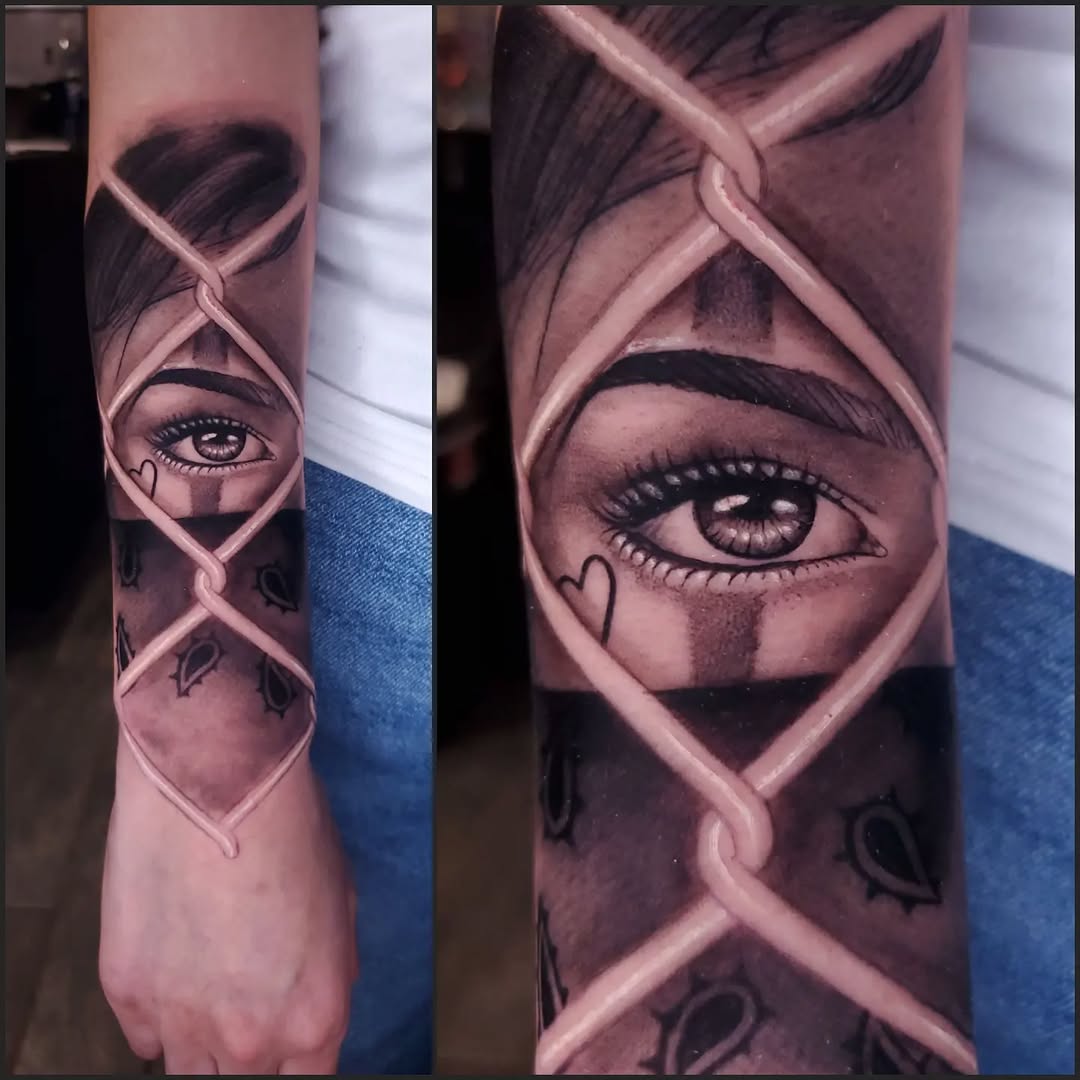 Eye behind chain link fence realism tattoo on the forearm by BoogaInk