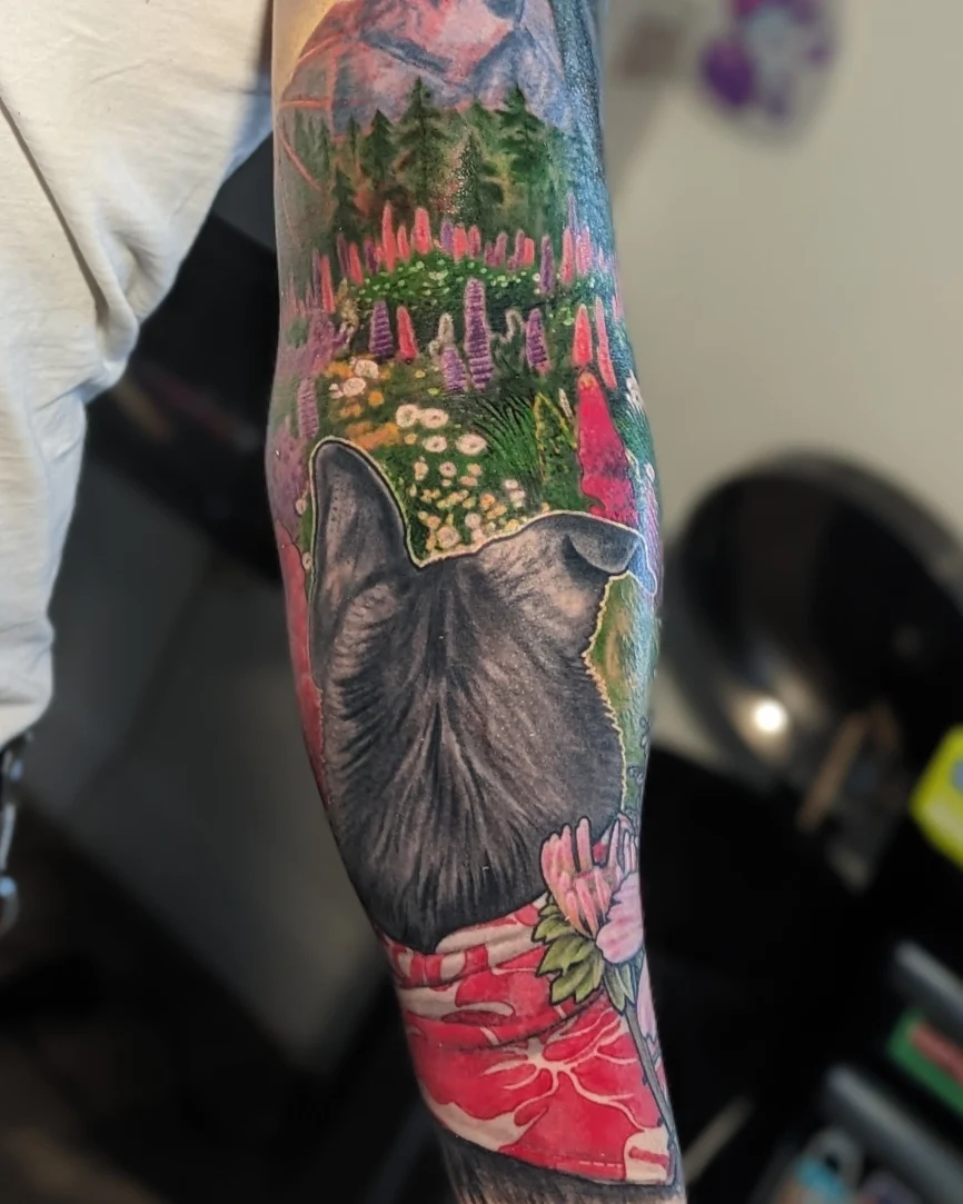 Bear and floral landscape realism tattoo on the forearm by Jay Trip