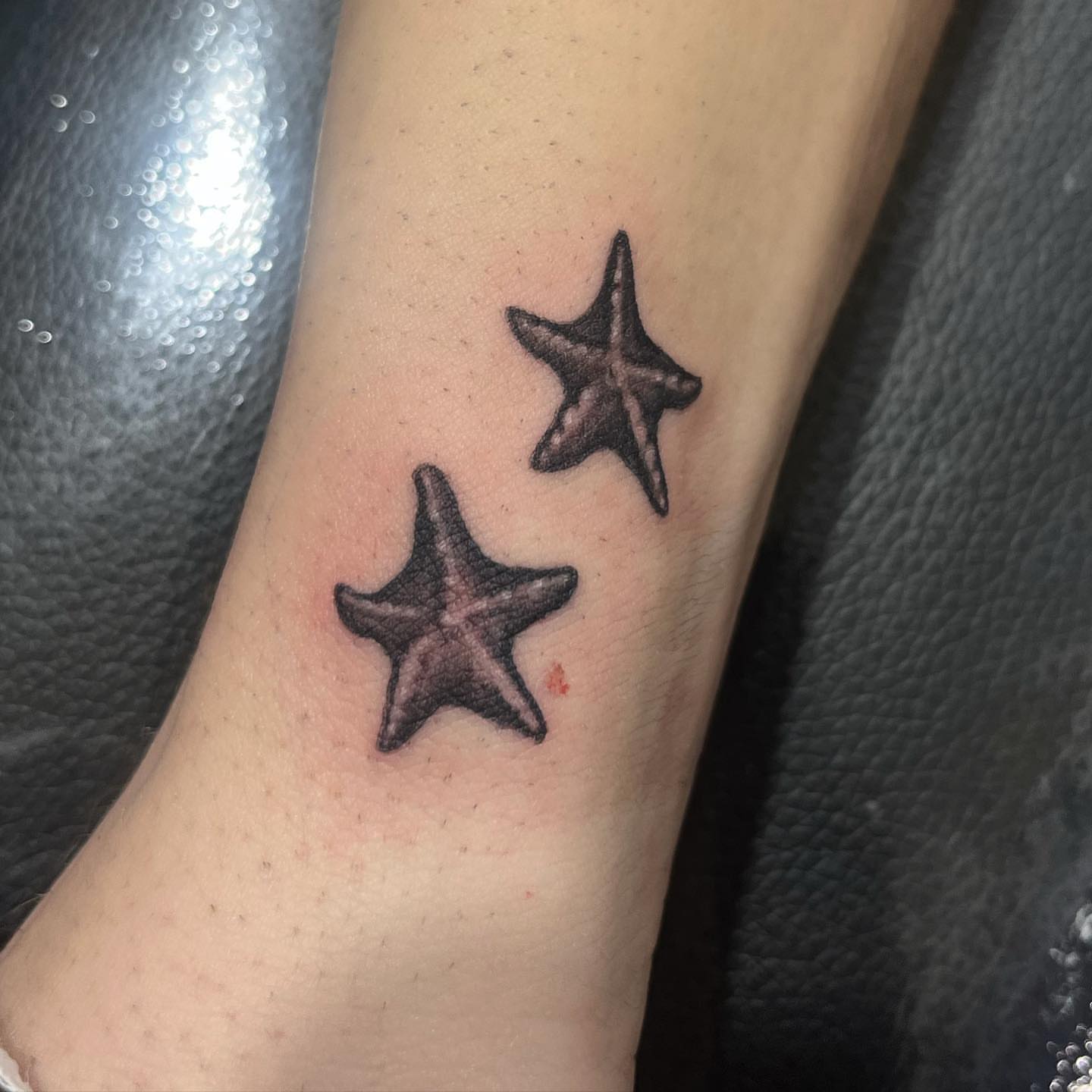 Starfish black and grey tattoo on the forearm by Morgan Jones