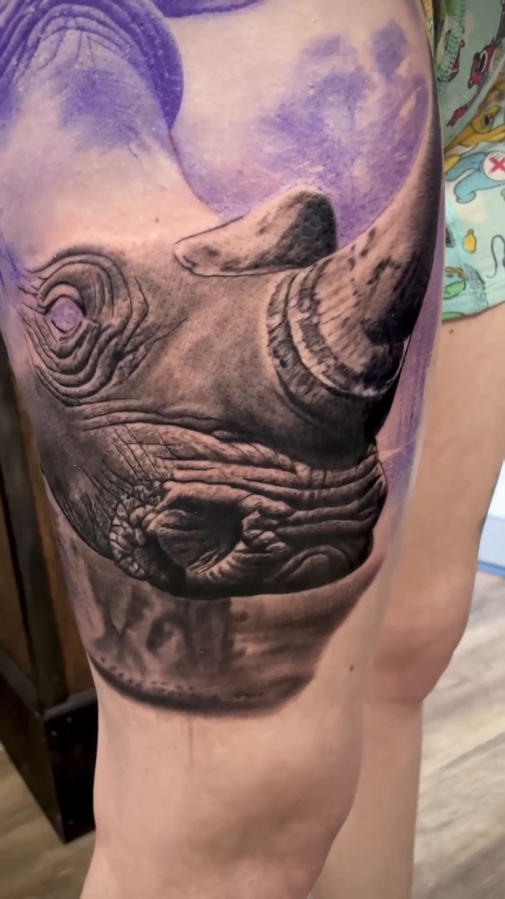 Rhino head with purple clouds realism tattoo by Charlie