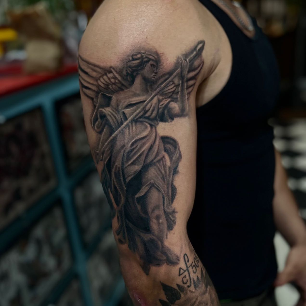 Angel with sword realism tattoo on the upper arm by Wolf of Wall St.