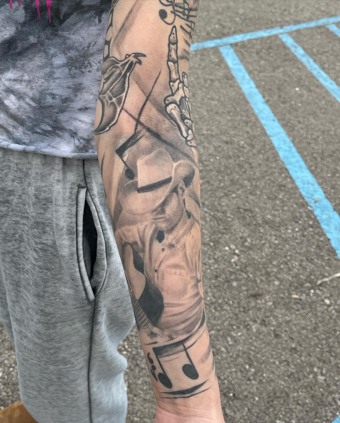 Musician playing guitar realism tattoo on the forearm by Antonio Massimino