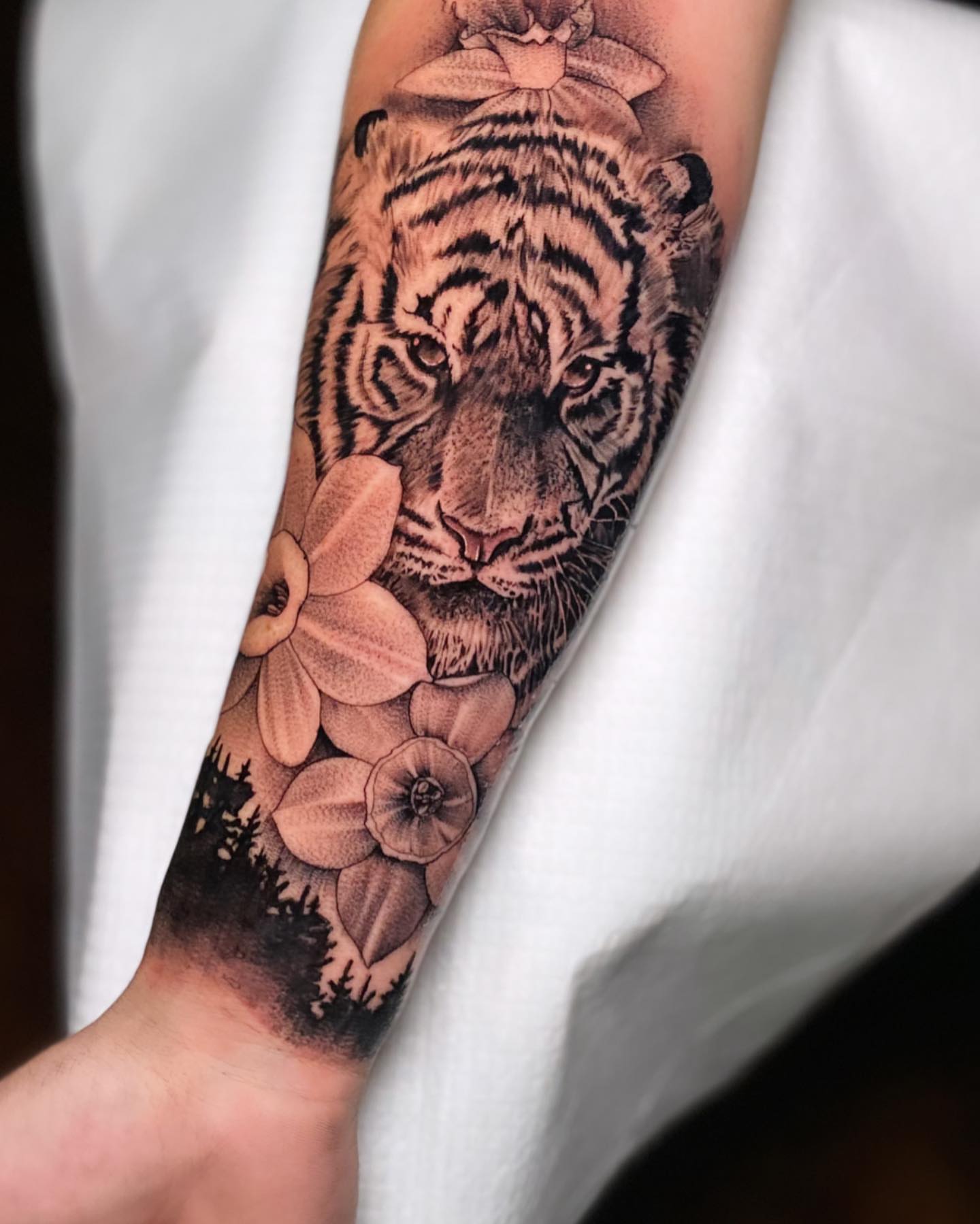 Tiger and flowers realism tattoo on the forearm by Jared Soto