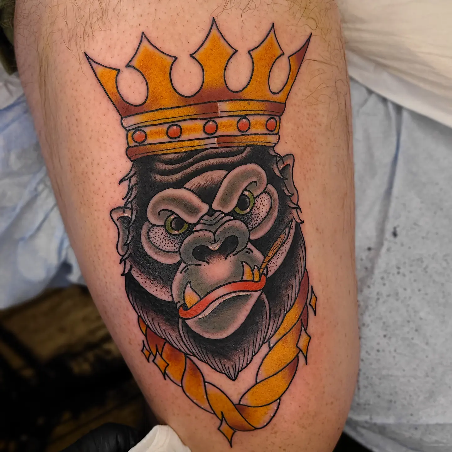 Gorilla wearing crown realism tattoo on the thigh by Noah Crow